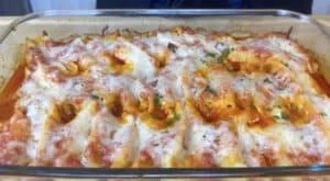 Cheesy baked pasta shells with tomato sauce in a glass dish, topped with fresh parsley. Perfect comfort food!